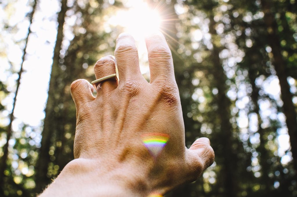 Quantum Healing: Unraveling the Secrets of Energy Medicine. Person's hang reaching out sunlight