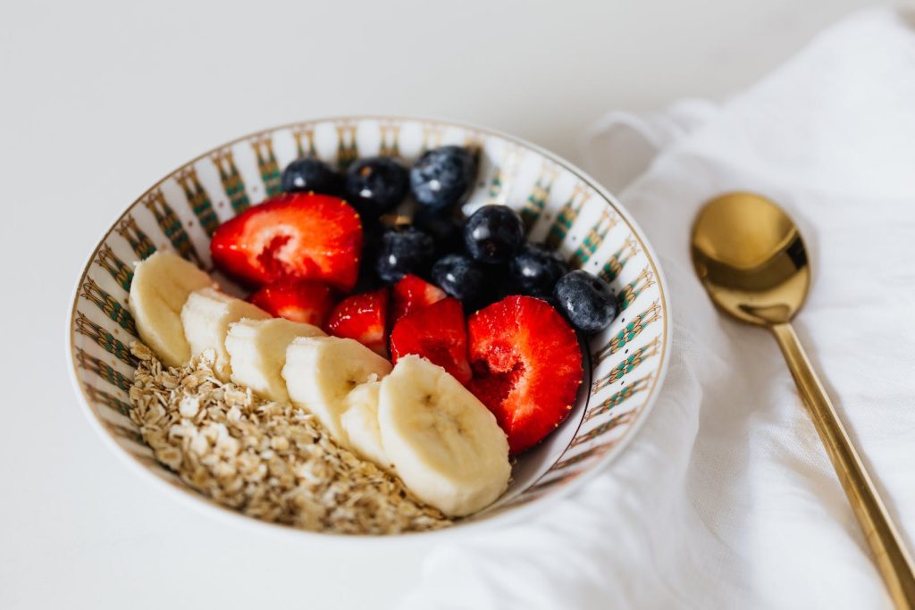 A bowl of oatmeal with blueberries, almonds, and honey.