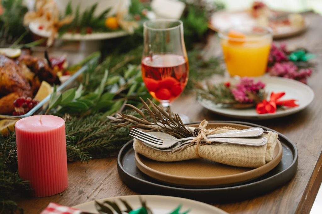 A glass of red wine and vegies on a wooden board.